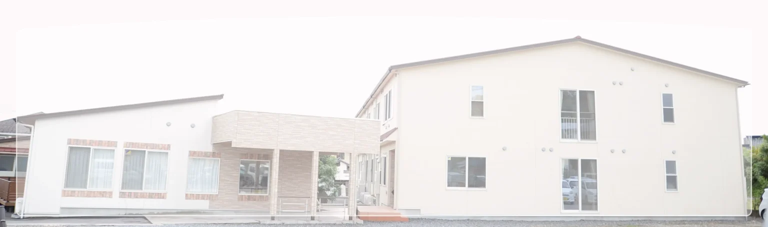 介護施設の建物外観。白を基調とした複数棟の平屋建て施設。